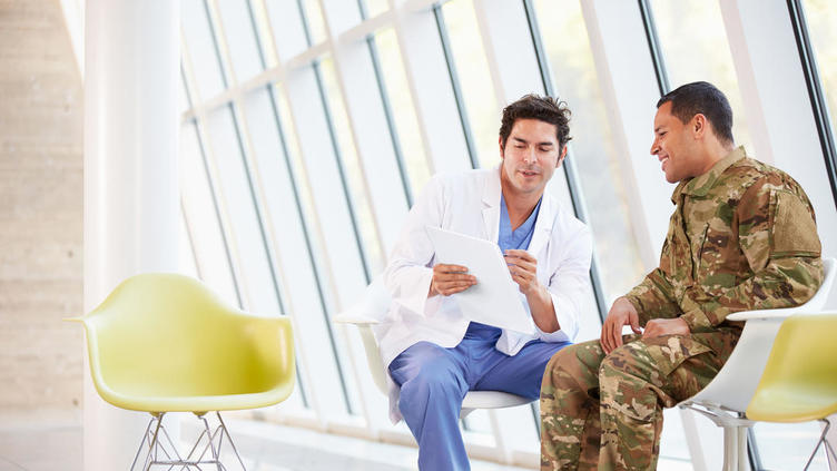 Military personnel chatting to a doctor