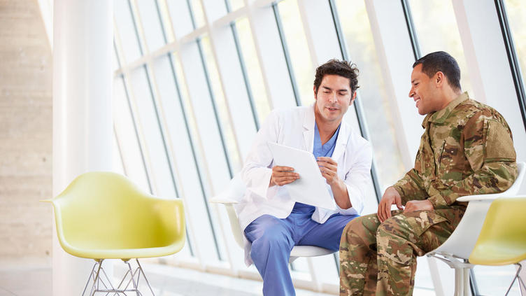 Military personnel chatting to a doctor