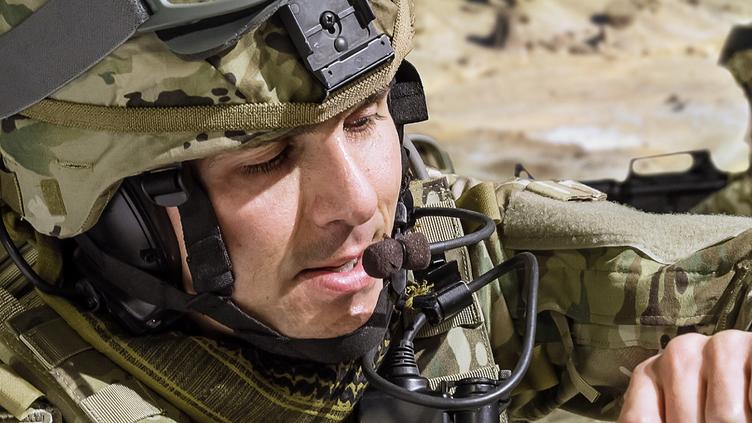 man in military uniform in the field with helmet on