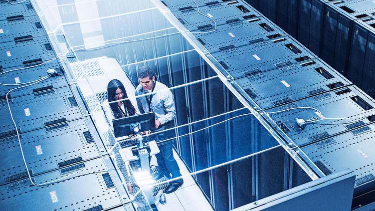 view from above server racks with two coworkers looking at a monitor