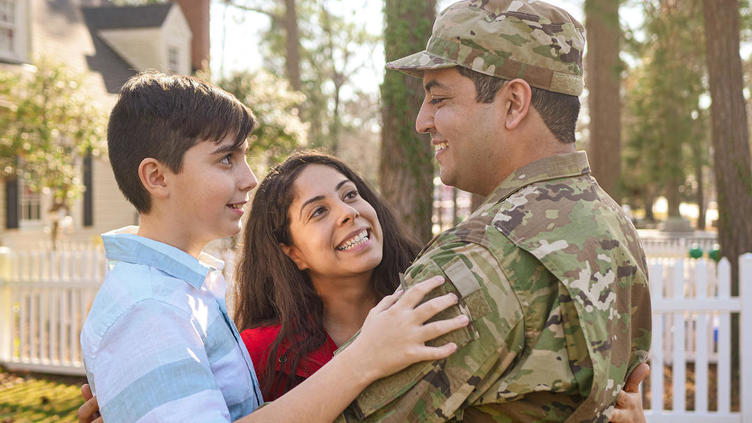 Solider embracing wife and child