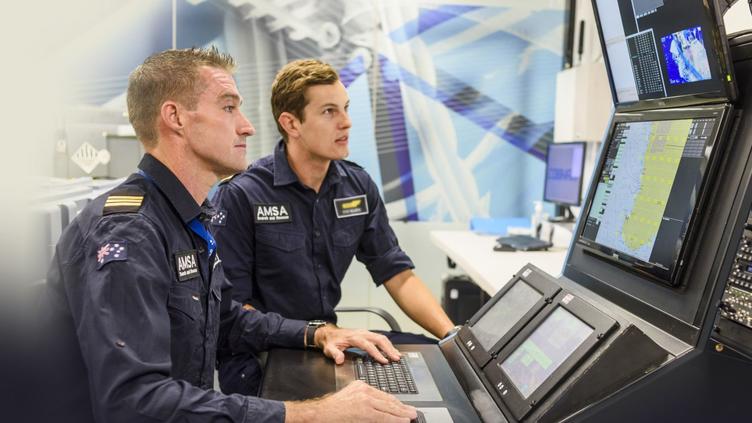 two men working at control panel with uniforms on