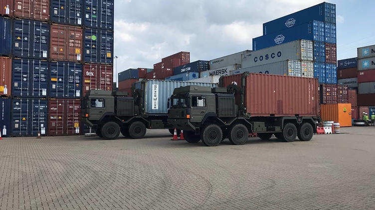 trucks in front of shipping containers