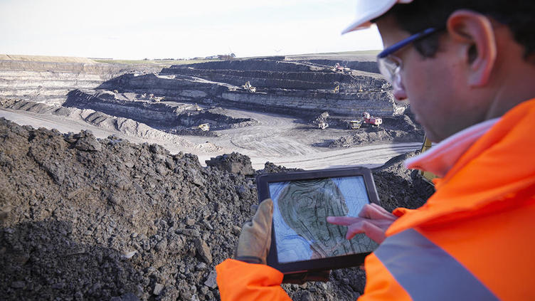 Environmental Engineer examining data on a tablet at excavation site