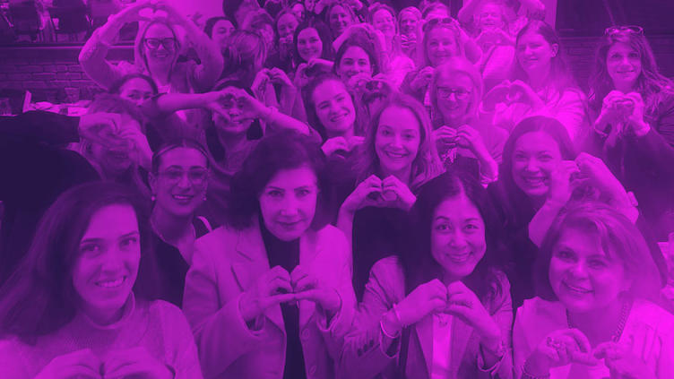 Women in a group picture with hand-hearts