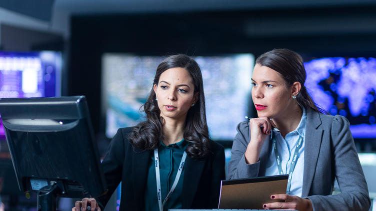 two coworkers collaborating next to a monitor